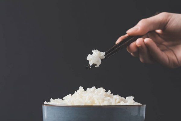 cooked rice from bowl with chopsticks