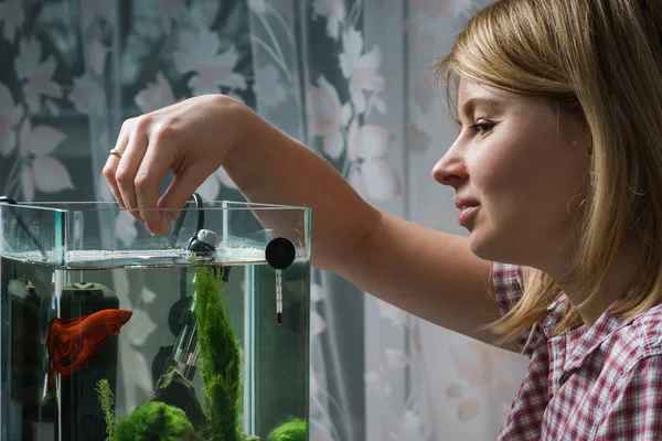 young woman feeding fish