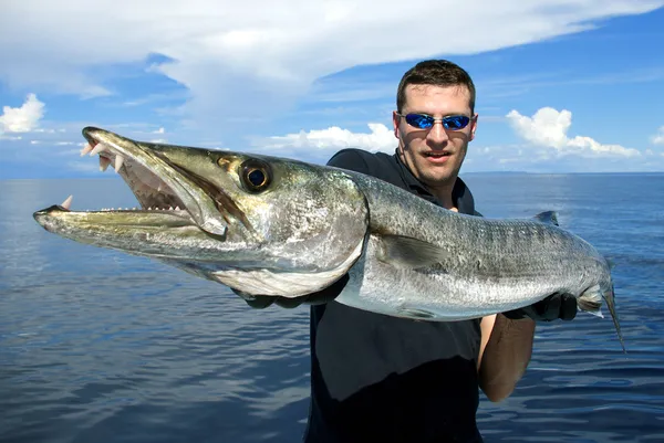 man holding giant barracuda